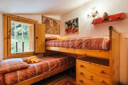 1 Schlafzimmer mit 2 Etagenbetten und einem Fenster in der Unterkunft CENTRAL WOODEN CHALET WITH FOREST VIEW in Madonna di Campiglio