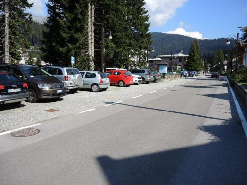 a street with cars parked in a parking lot at CENTRAL WOODEN CHALET WITH FOREST VIEW in Madonna di Campiglio