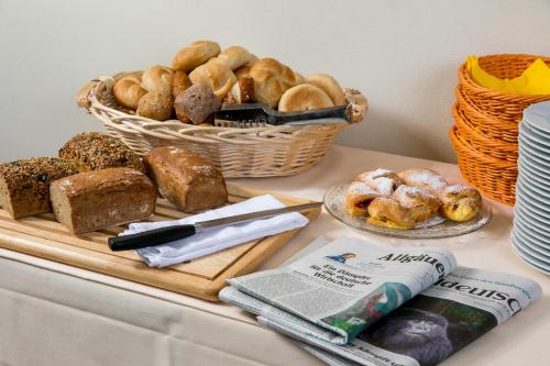 a table with a basket of bread and a basket of pastries at CityHotel Kempten in Kempten