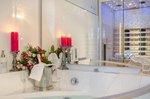 a bathroom with a sink with two candles and flowers at Luxuslodge Wernigerode in Wernigerode