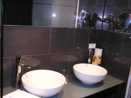 a bathroom with two white sinks and a mirror at Hotel zur Promenade in Donauwörth