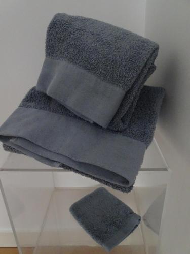a pile of gray towels sitting on a glass shelf at Le Loft, l'annexe in Lorient