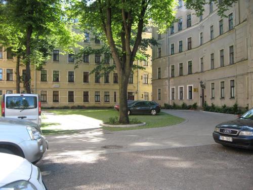 a parking lot in front of a large building at Central Park Rooms in Riga