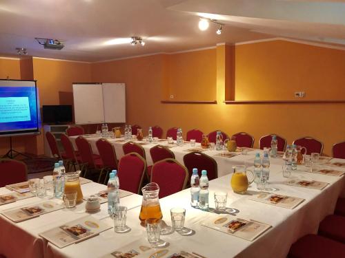 une salle de conférence avec des tables, des chaises et un écran dans l'établissement Gołąbek Łeba, à Łeba