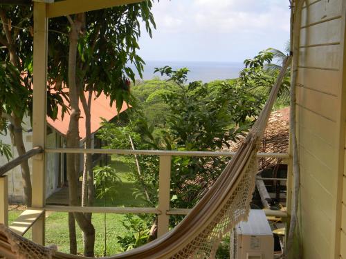 a hammock in a room with a view of the ocean at Palhoça da Colina in Fernando de Noronha