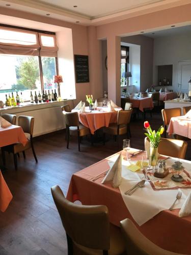 ein Esszimmer mit Tischen und Stühlen sowie ein Restaurant in der Unterkunft TERAMO Restaurant Hotel Mühlenstein in Grünhagen