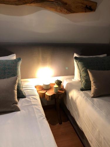 two beds in a room with a lamp on a table at Braancamp 65 in Porto