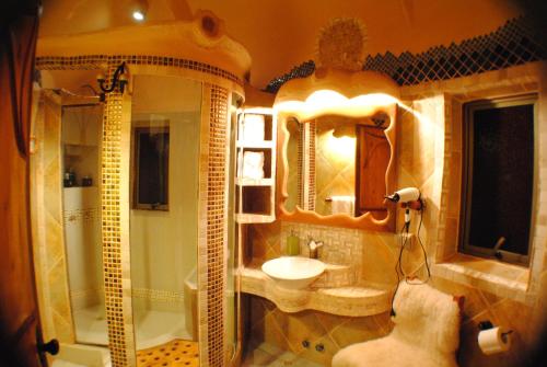 een badkamer met een wastafel, een douche en een spiegel bij Cascada Lodge Cajon del Maipo in San José de Maipo