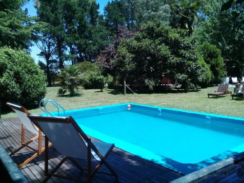 a swimming pool with a chair and a table and a chair at La Nilda in Tandil