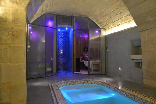 a bathroom with a tub with a woman in the shower at Palazzo Muro Leccese Relais de Charme & Wellness in Muro Leccese