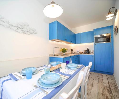 a kitchen with blue cabinets and a table with blue dishes at Faro della Madonetta in Bonifacio