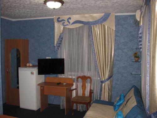 een slaapkamer met een bed, een tafel en een bureau bij Hotel Dubrava in Poltava