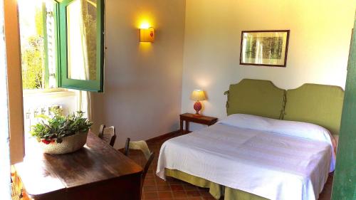 a bedroom with a bed and a table and a window at Tenuta San Calogero App Rosmarino in Agnone Bagni