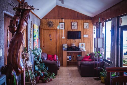 a living room with couches and a tv at Cabañas & Hostal Tojika in Hanga Roa
