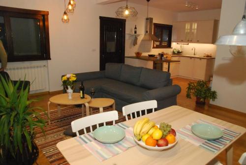 a living room with a table with a bowl of fruit at Wass House in Kosjerić