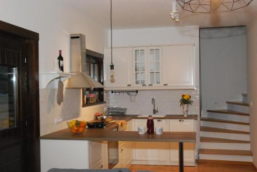 a kitchen with white cabinets and a counter top at Wass House in Kosjerić
