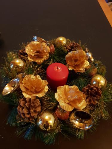 a christmas centerpiece with a candle and christmas decorations at Guest House Karov - 2 Stars in Chepelare