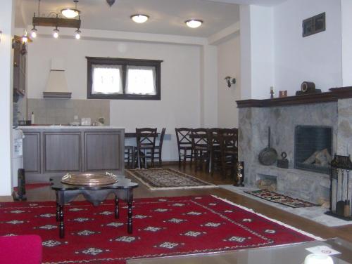 a living room with a fireplace and a table and chairs at Casa La Kola Krusevo in Kruševo