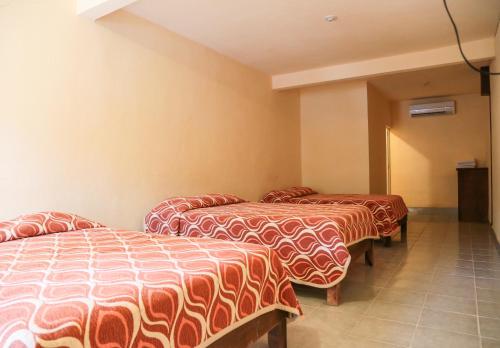 a row of three beds in a room at Hotel Santa Rita in Huichihuayán