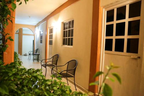 a hallway of a house with chairs and a door at Hotel Santa Rita in Huichihuayán