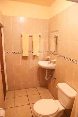 a bathroom with a toilet and a sink at Hotel Santa Rita in Huichihuayán