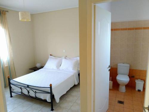 1 dormitorio con cama blanca y aseo en Margaret's House, en Cefalonia