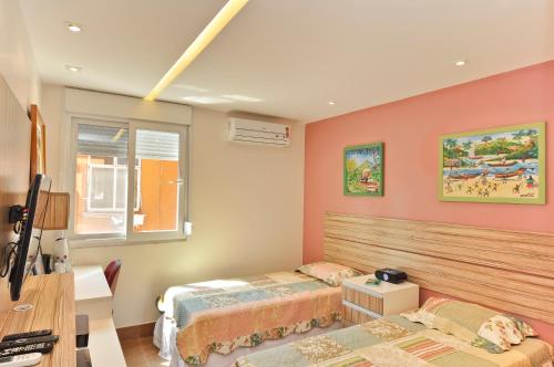 1 dormitorio con 2 camas y escritorio en Lapa Chêca Guest House, en Río de Janeiro