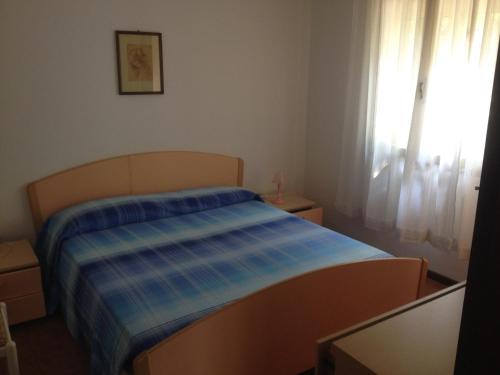 una camera da letto con un letto con una coperta blu sopra di Villa Menazzi a Lignano Sabbiadoro