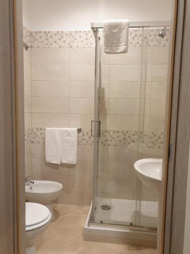 a bathroom with a shower and a toilet and a sink at Hotel Chopin in Fiumicino