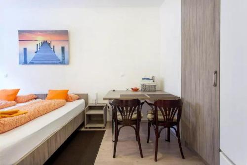 a bedroom with a bed and a table and chairs at Apartments FABRKA in Ljubljana