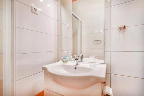 a white bathroom with a sink and a shower at Apartments FABRKA in Ljubljana