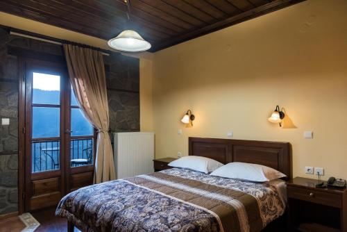 a bedroom with a bed and a large window at Hotel Kroupi in Elati