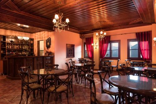 エラティ・トリカラにあるHotel Kroupiのテーブルと椅子のあるレストラン、バー