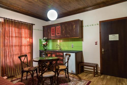 a kitchen with a table and chairs and a sink at Hotel Kroupi in Elati Trikalon
