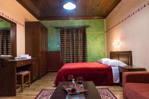 a hotel room with a bed with a red blanket at Hotel Kroupi in Elati Trikalon