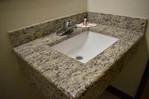 a bathroom sink with a toothbrush in it at Super 8 by Wyndham Newport News/Jefferson Ave. in Newport News