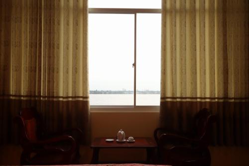 a room with a window with a table and chairs at Rang Dong Hotel in My Tho