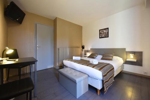 - une chambre avec un lit, un bureau et une télévision dans l'établissement Hôtel La Mirandole, à Tournus