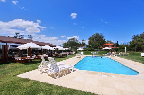 una piscina con sillas, mesas y sombrillas en Hotel Terraza del Mar, en Punta del Este