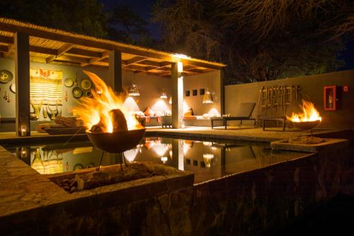 a fire pit in a patio with a pool at night at Hotel Desertica in San Pedro de Atacama