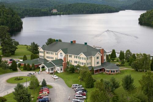 an aerial view of a large house on a lake at Auberge du Lac-à-l'Eau-Claire in Saint-Alexis-des-Monts
