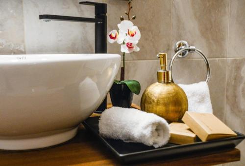 a bathroom with a sink and a toilet and books at 5inAthens in Athens