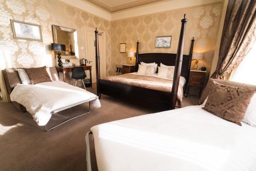 a hotel room with two beds and a chair at Brooks Guesthouse in Bath