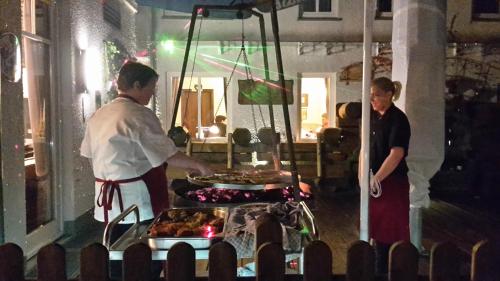 two people standing in a kitchen preparing food at Hotel Bigger Hof - Wirtshaus Platzhirsch am Jahnplatz in Olsberg
