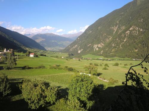 a large green field with mountains in the background at Hotel Chavalatsch in Tubre