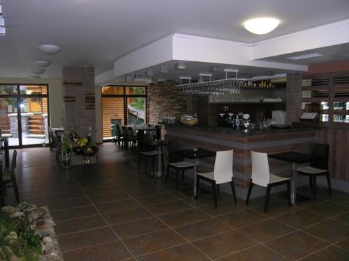 a restaurant with a bar with white chairs and tables at Apartmán Hrabovo 203 Fatrapak 2 in Ružomberok