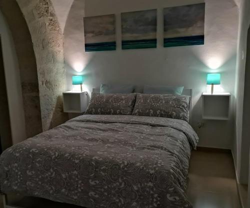 una camera da letto con un letto con due lampade su entrambi i lati di Come una volta a Trani