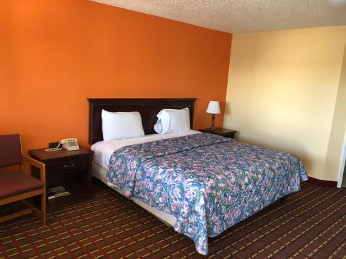 une chambre d'hôtel avec un lit et une table avec un téléphone dans l'établissement Dogwood Park Inn, à Springfield