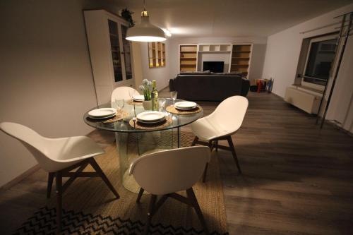 a dining room with a table and white chairs at Apartment Heddesheim in Heddesheim