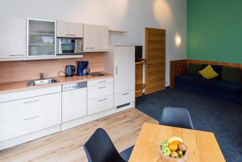 a kitchen with a table with a bowl of fruit on it at Ibex Lodge in Sankt Anton am Arlberg